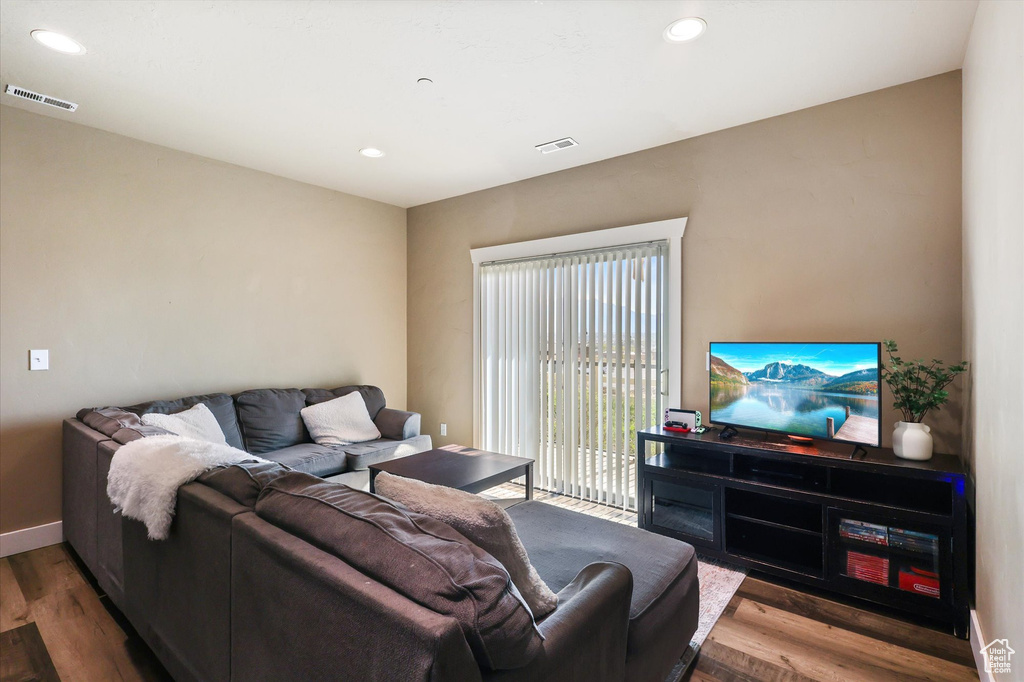 Living room with wood finished floors, visible vents, and recessed lighting