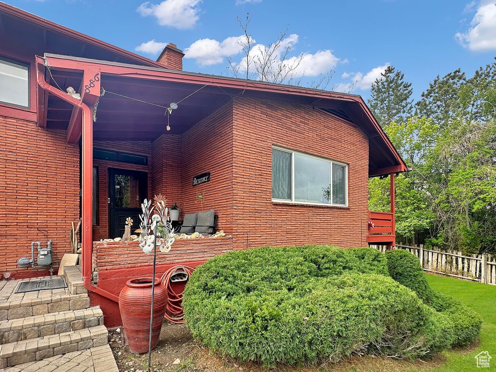 View of front of house featuring a chimney and fence