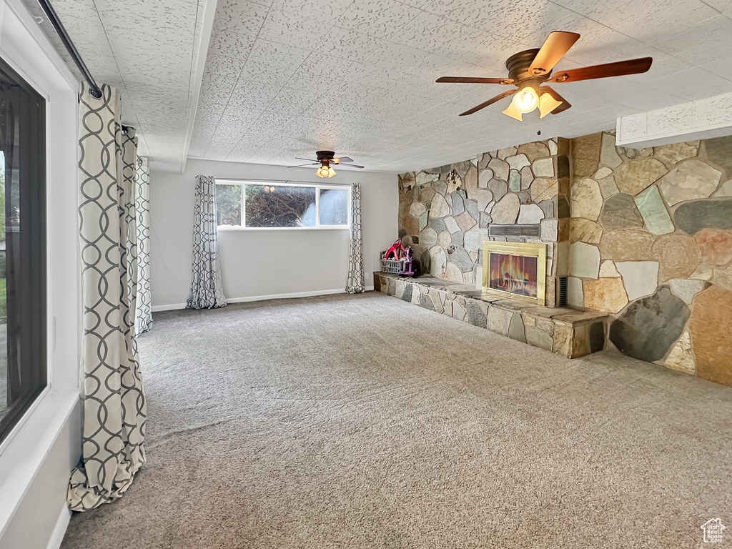 Unfurnished living room featuring carpet, a ceiling fan, and baseboards