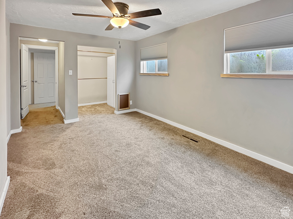 Unfurnished bedroom featuring carpet flooring, a closet, a ceiling fan, visible vents, and baseboards