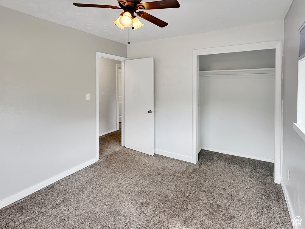Unfurnished bedroom featuring baseboards, ceiling fan, a closet, and carpet