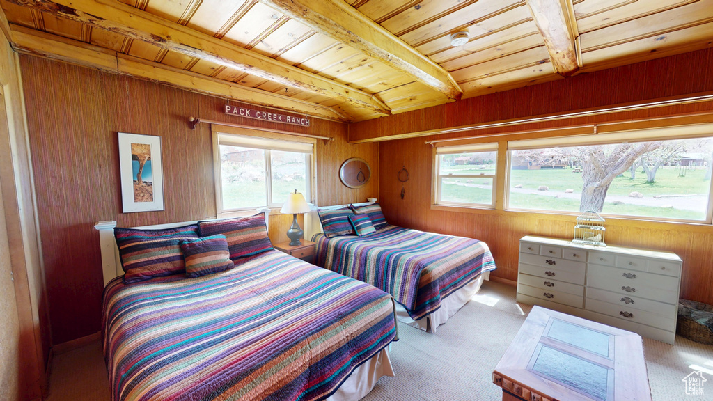Bedroom with carpet flooring, beamed ceiling, wooden ceiling, and multiple windows