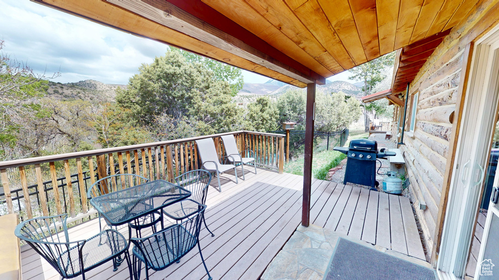 Wooden terrace featuring a mountain view, area for grilling, and outdoor dining space