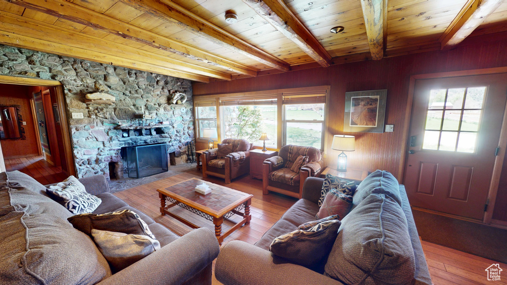Living room featuring wood ceiling, beam ceiling, a healthy amount of sunlight, and hardwood / wood-style floors