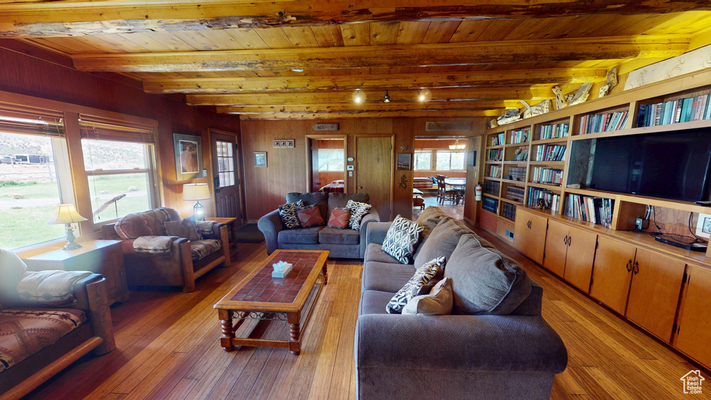 Living room with light wood-style floors, wooden ceiling, and beamed ceiling