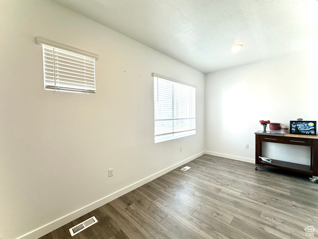 Empty room featuring wood finished floors and a textured ceiling