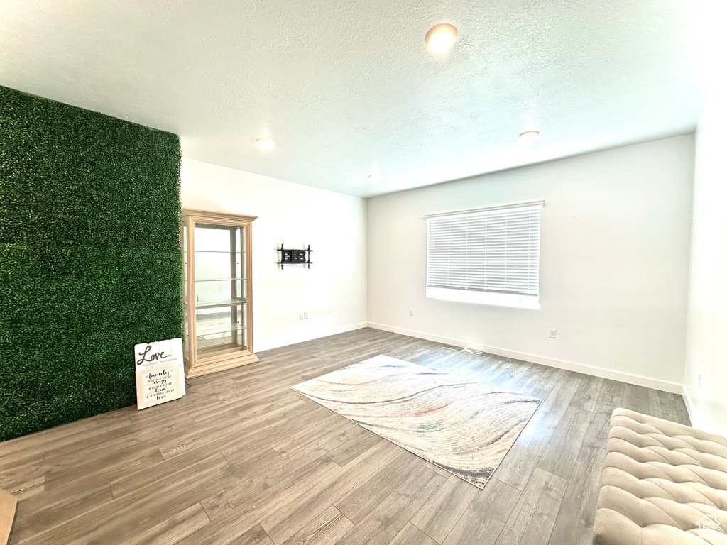 Spare room with wood finished floors and a textured ceiling