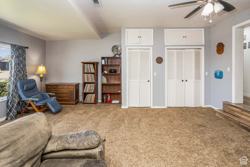 Living area with visible vents, ceiling fan, carpet, and baseboards