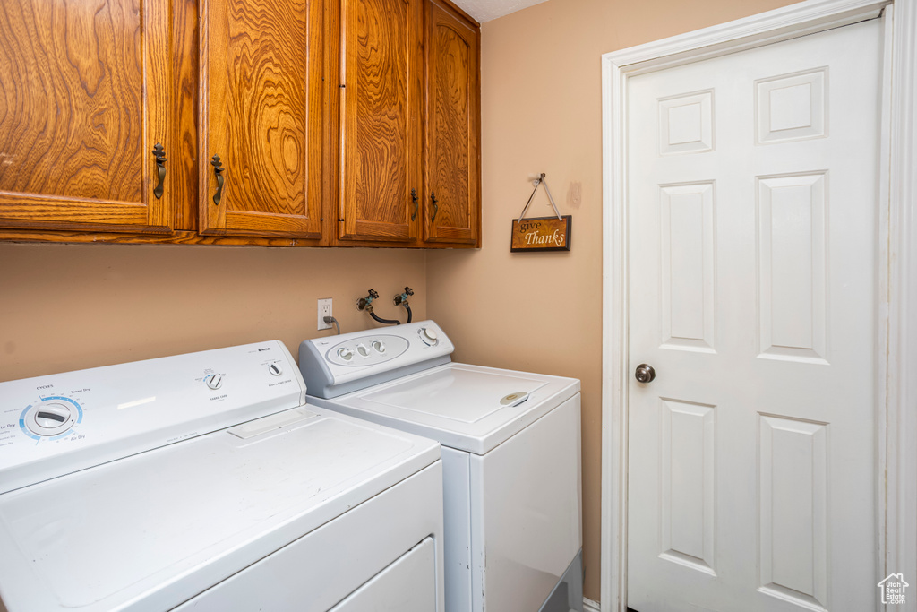 Washroom featuring cabinet space and washing machine and clothes dryer