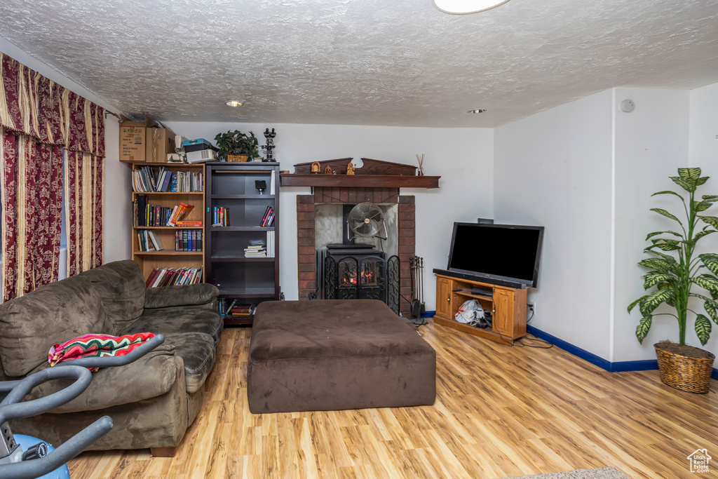 Living room with a textured ceiling, wood finished floors, and baseboards