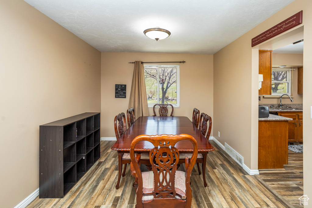 Dining room featuring baseboards, visible vents, and wood finished floors