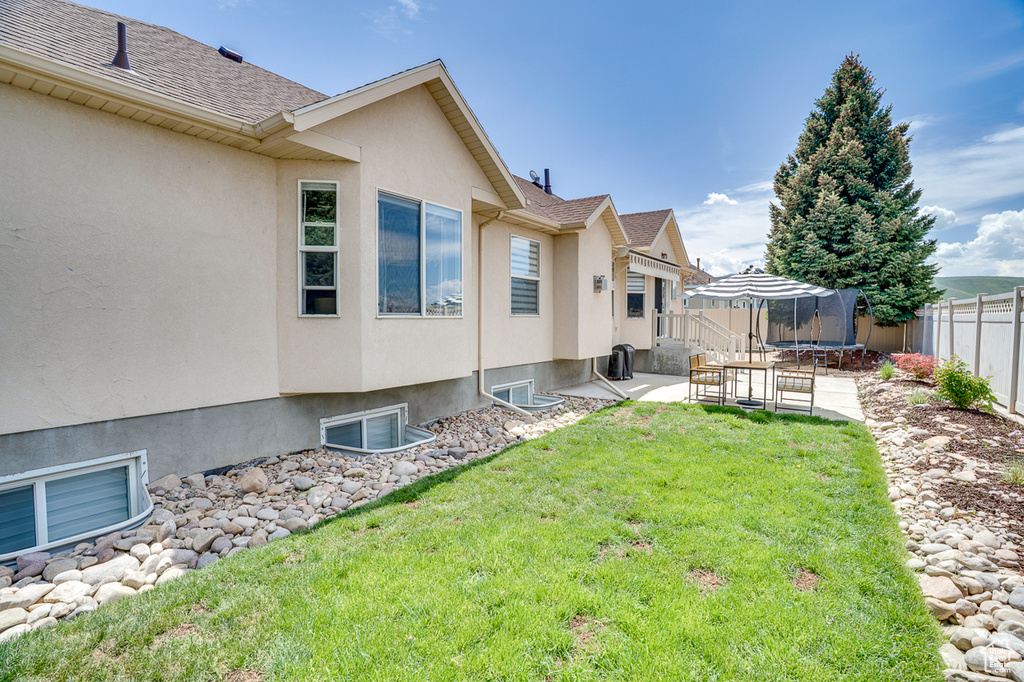 View of yard featuring a trampoline and a patio area