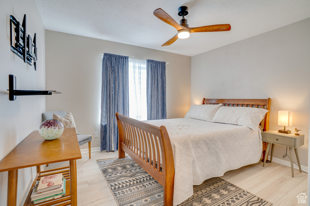 Bedroom featuring light wood-style flooring, ceiling fan, and baseboards