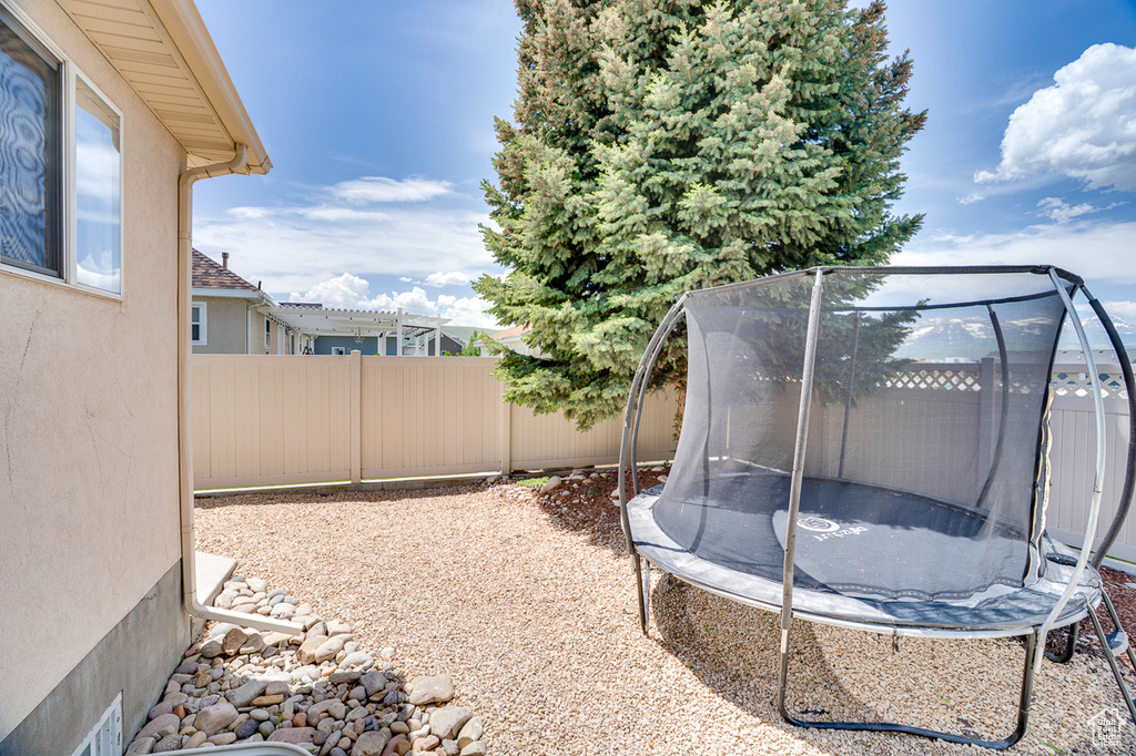Fenced backyard with a trampoline