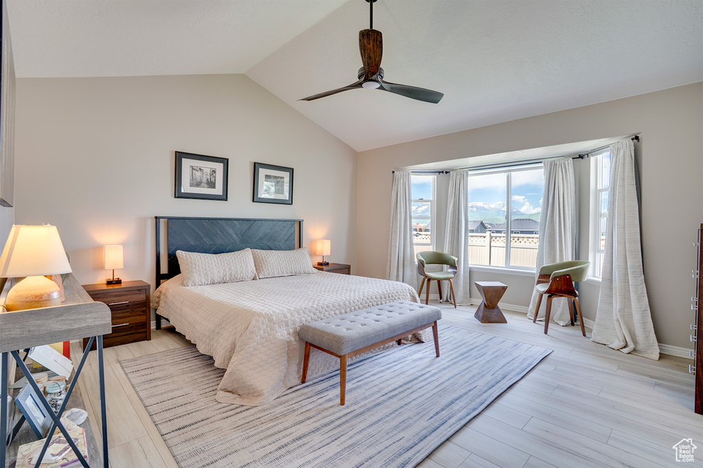 Bedroom with light wood-type flooring, vaulted ceiling, ceiling fan, and baseboards