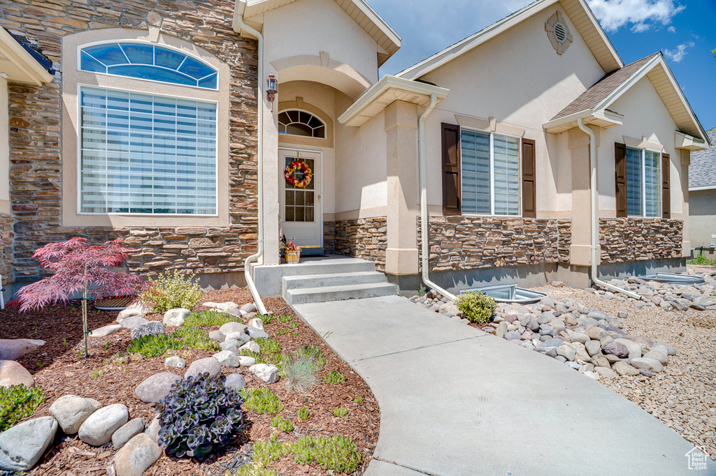 Entrance to property featuring stone siding and stucco siding