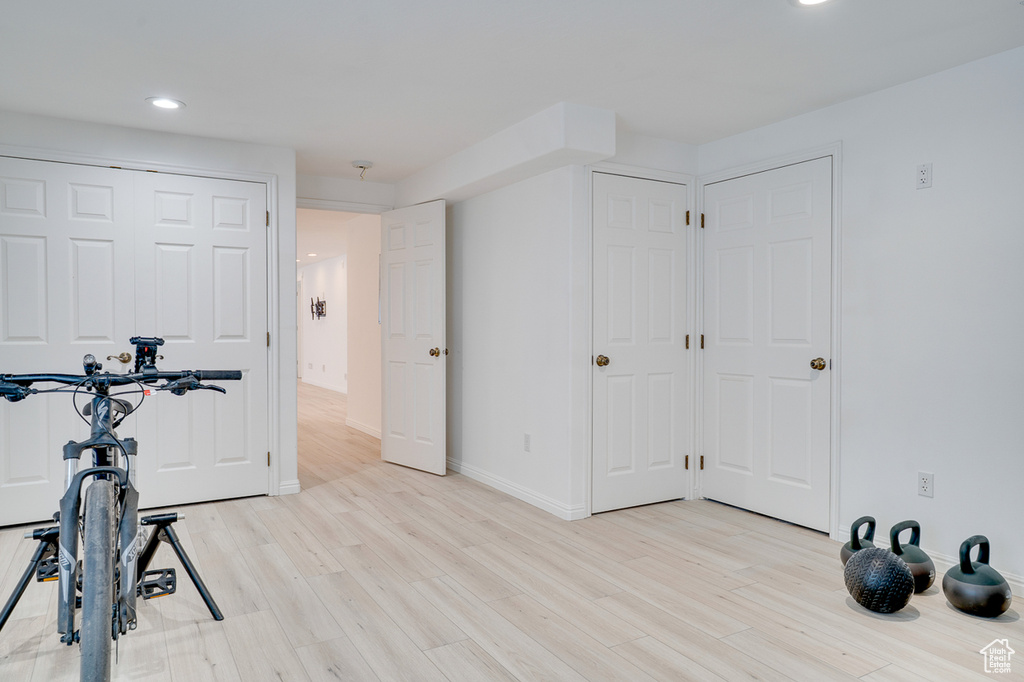 Exercise room with light wood-style flooring, recessed lighting, and baseboards