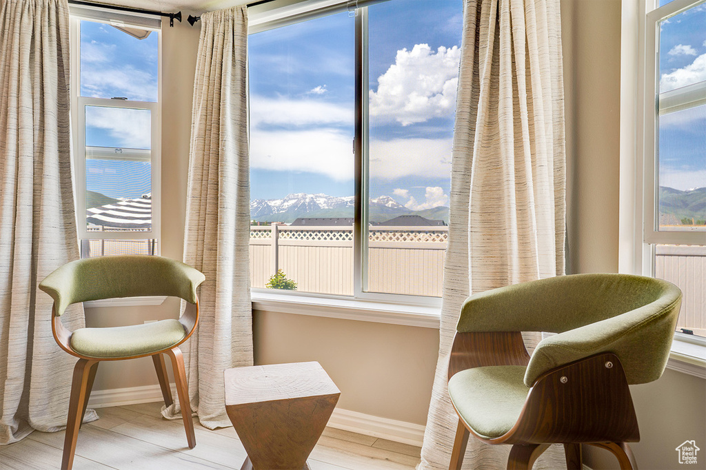 Sitting room with a mountain view, wood finished floors, and baseboards