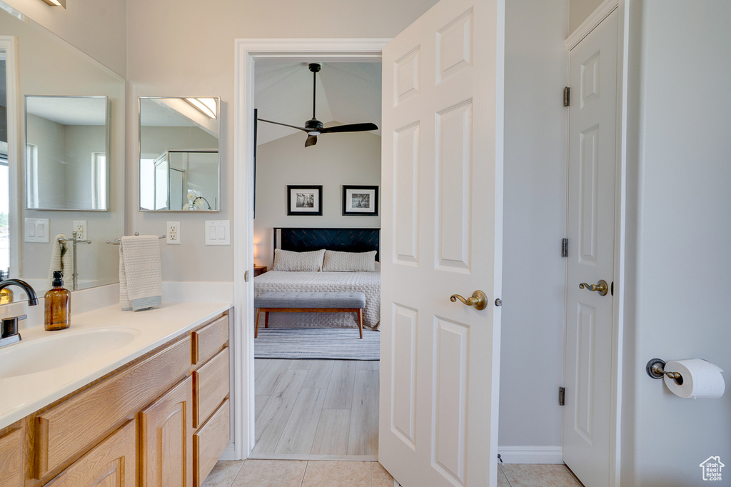 Ensuite bathroom featuring vanity, a ceiling fan, and tile patterned floors