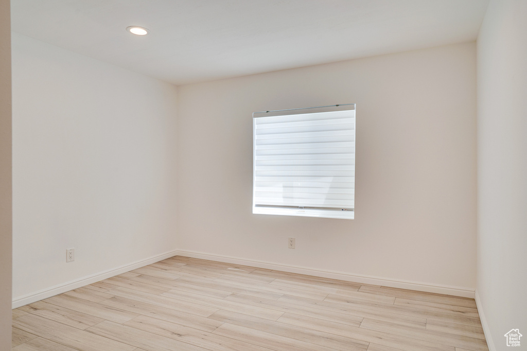 Empty room with light wood-style floors, recessed lighting, and baseboards