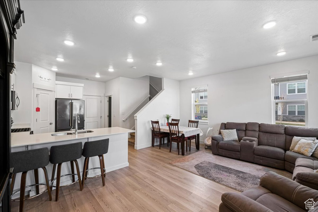 Living area with recessed lighting, stairway, light wood-type flooring, baseboards, and visible vents