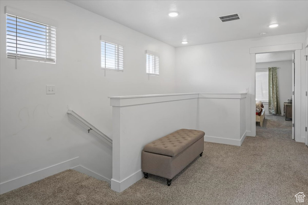 Living area featuring recessed lighting, carpet flooring, an upstairs landing, visible vents, and baseboards