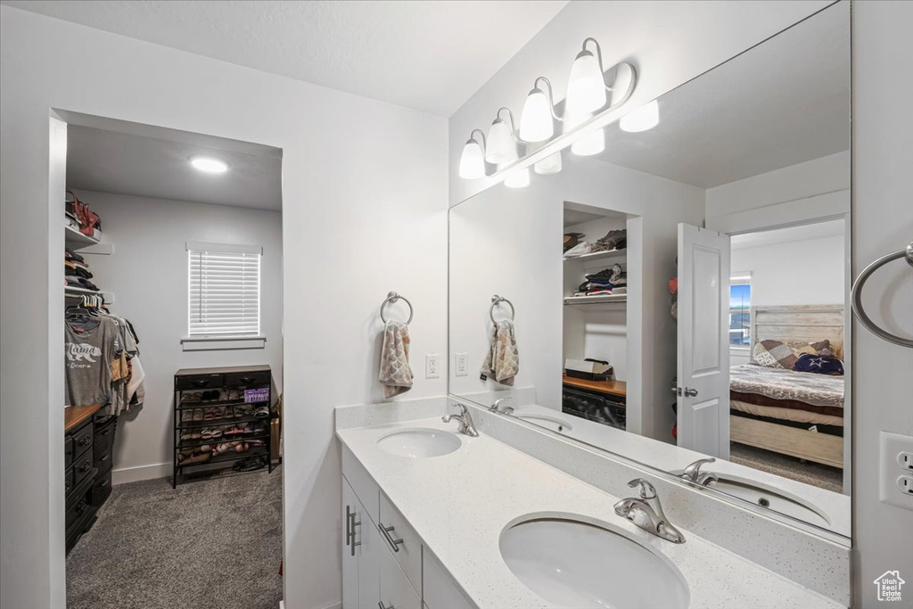 Full bathroom featuring a walk in closet, ensuite bathroom, and a sink