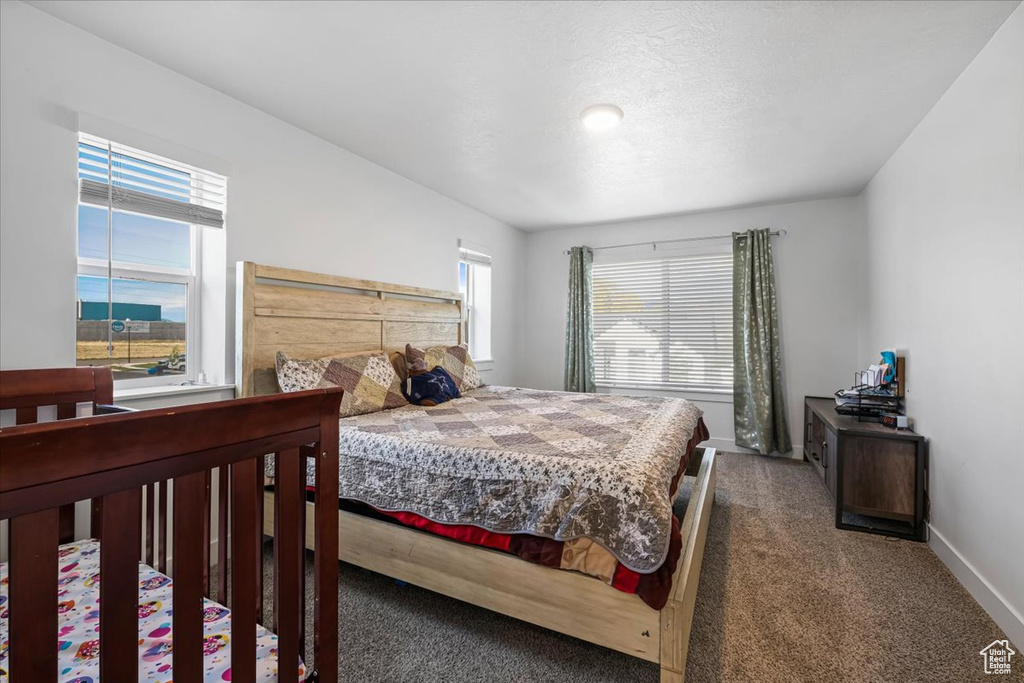 Bedroom featuring carpet and baseboards