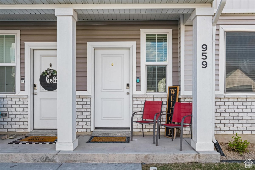View of exterior entry featuring a porch and stone siding