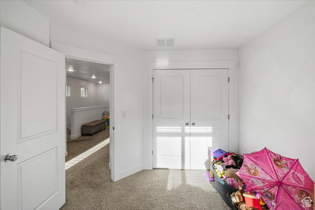 Bedroom featuring carpet, visible vents, baseboards, and a closet