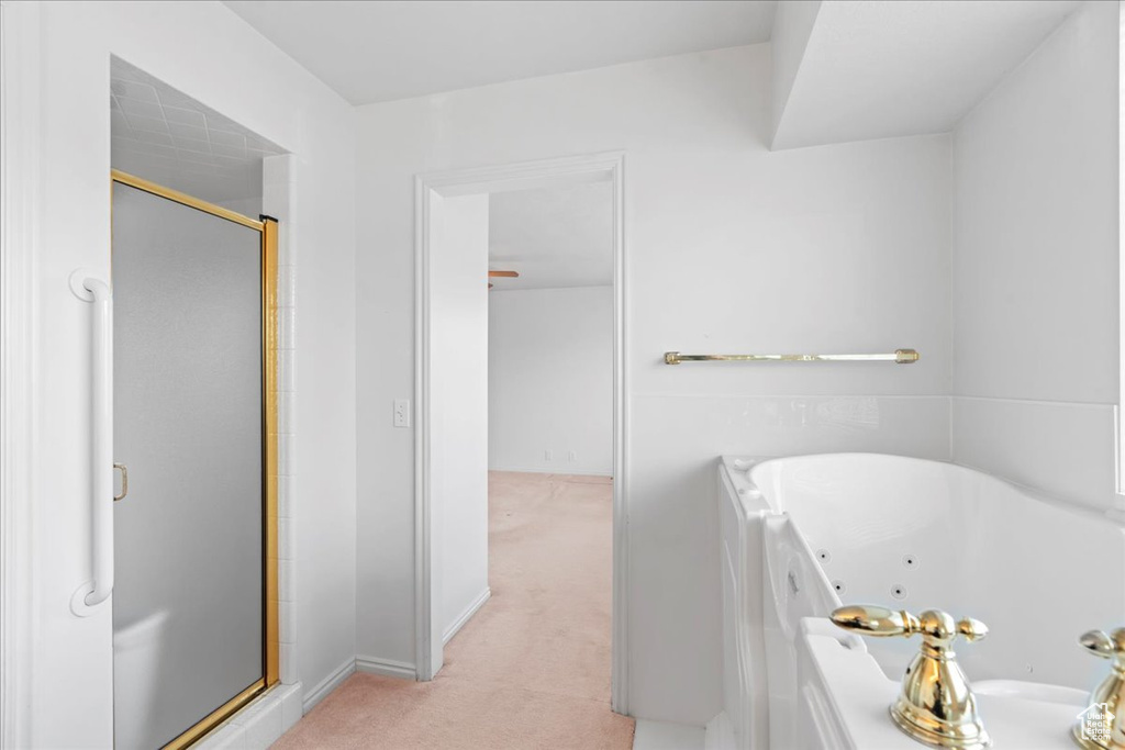 Bathroom with a stall shower and a jetted tub