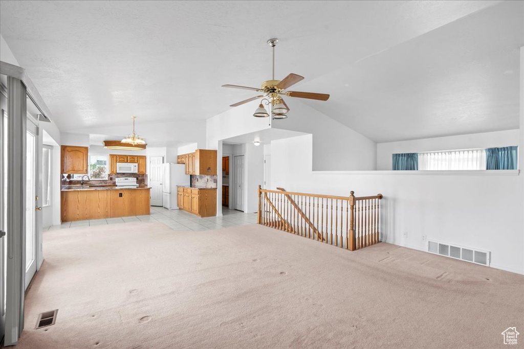 Unfurnished living room with visible vents, light carpet, and lofted ceiling