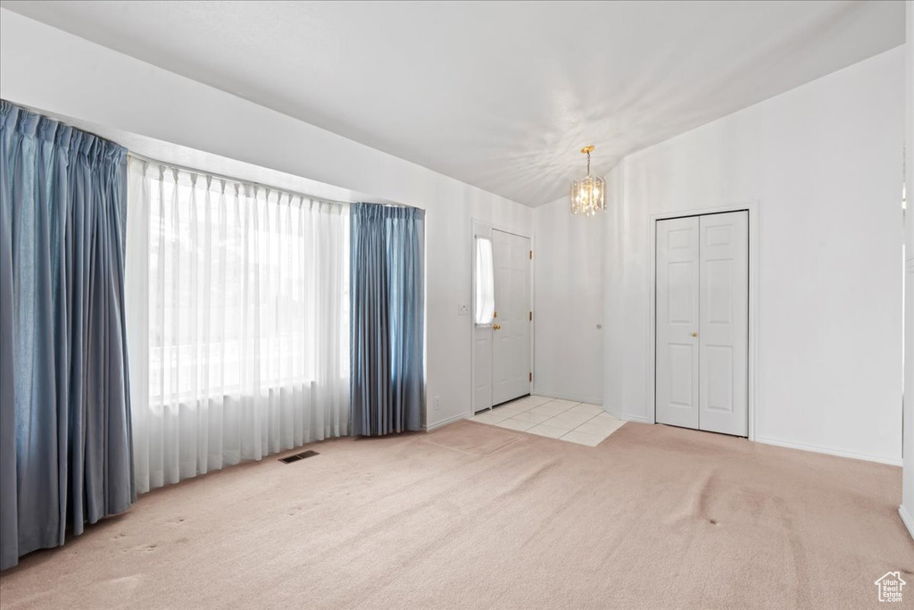 Interior space featuring a chandelier, visible vents, and carpet