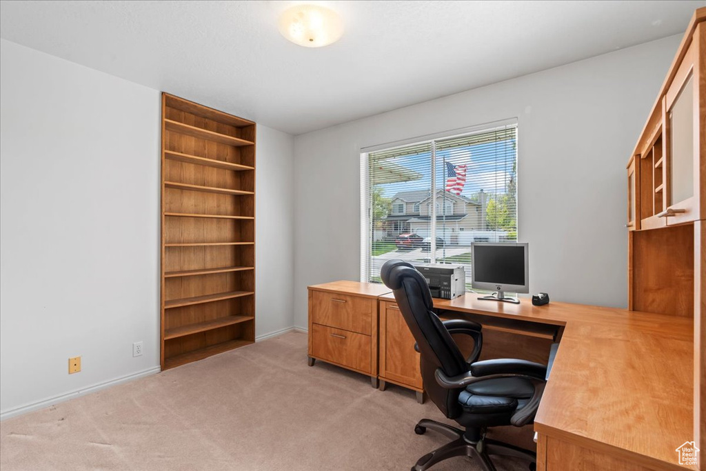 Office area with baseboards and light carpet