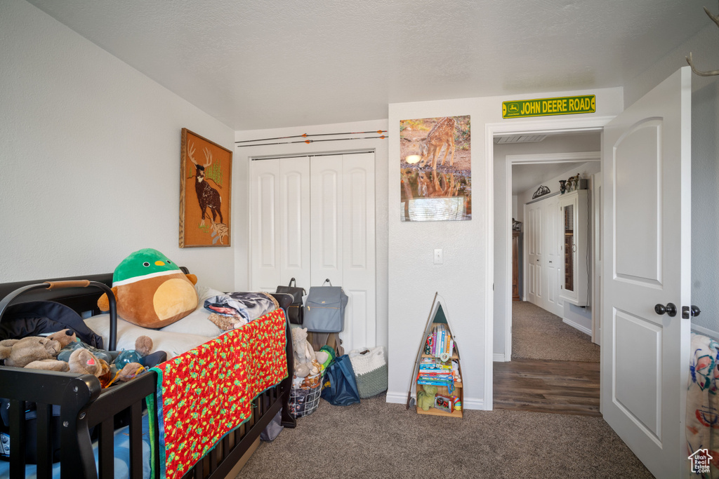 Carpeted bedroom featuring a closet and baseboards