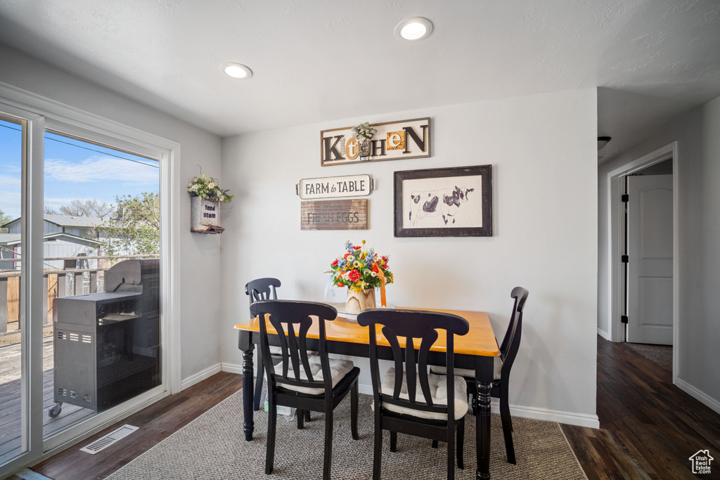 Dining space featuring dark wood-style floors, recessed lighting, visible vents, and baseboards