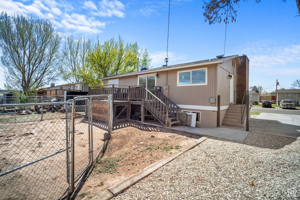 View of front of property featuring a gate, stairs, a chimney, a deck, and fence