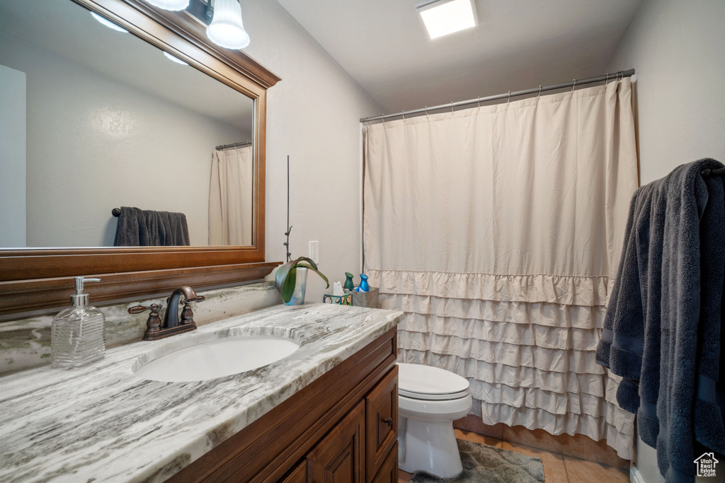 Bathroom with tile patterned floors, toilet, and vanity