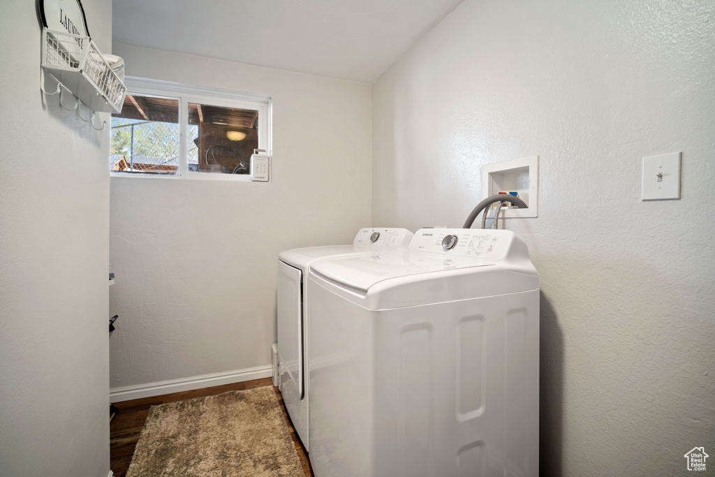 Laundry room featuring washing machine and clothes dryer, wood finished floors, laundry area, and baseboards