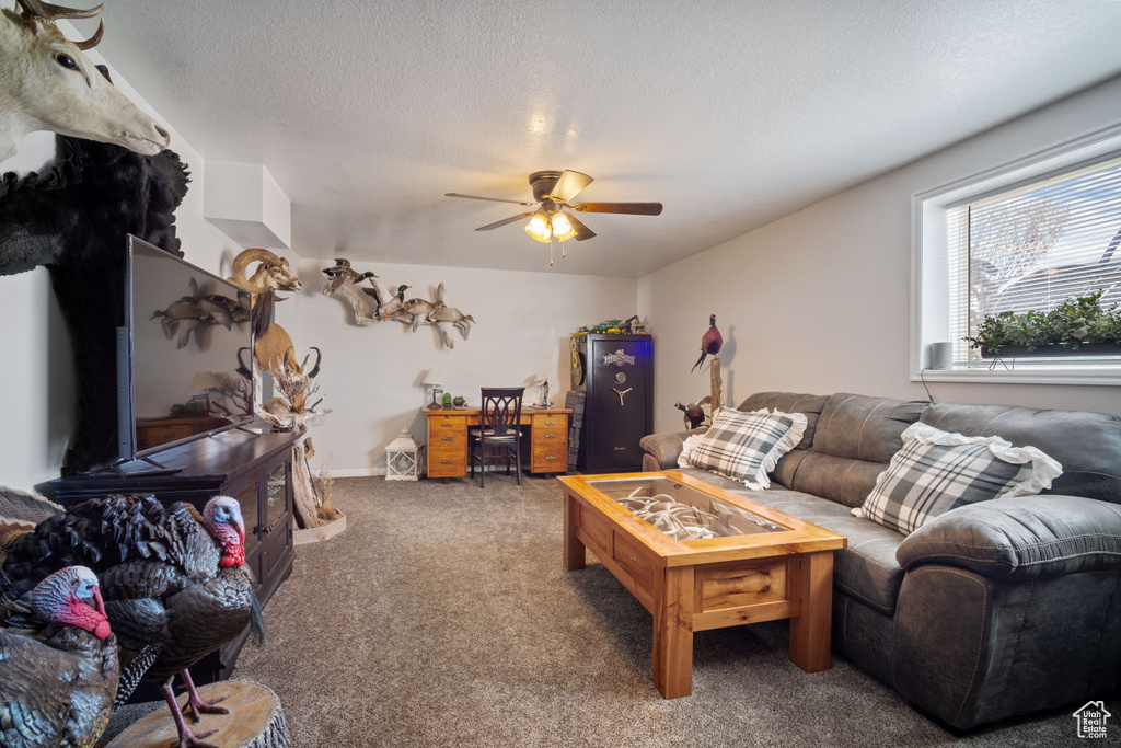Carpeted living room featuring a textured ceiling and a ceiling fan