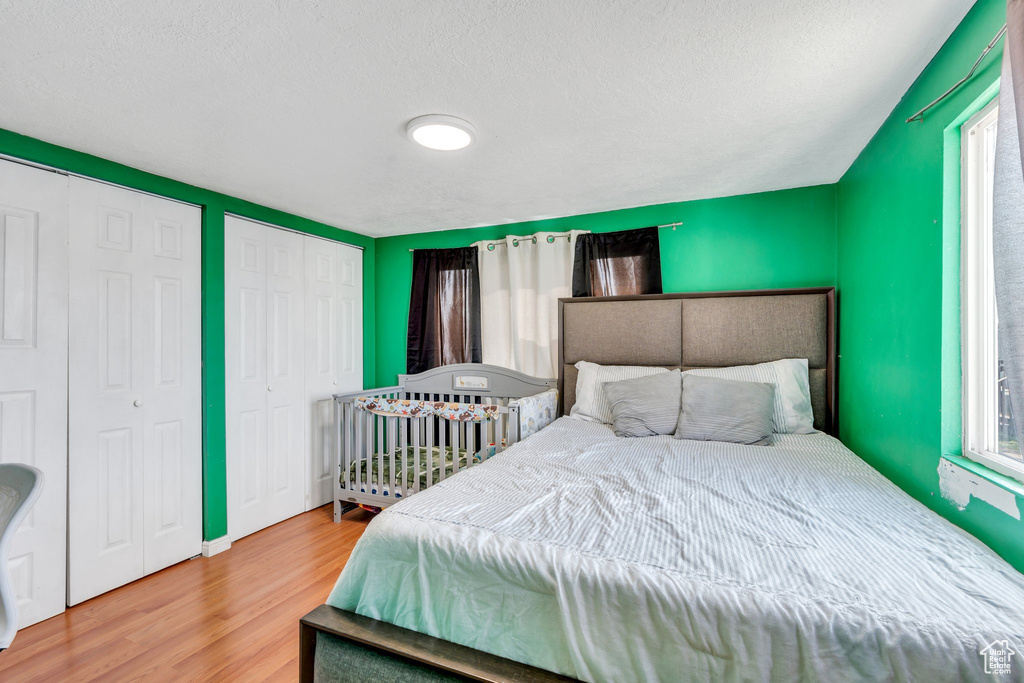 Bedroom with a textured ceiling and wood finished floors