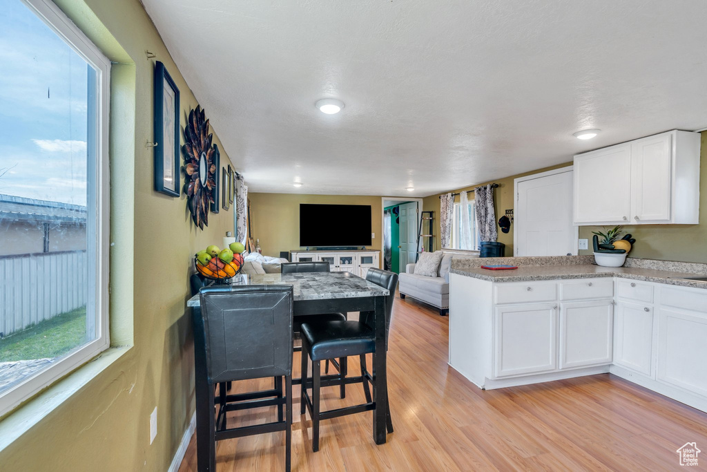 Kitchen featuring plenty of natural light, light wood-style flooring, and white cabinets