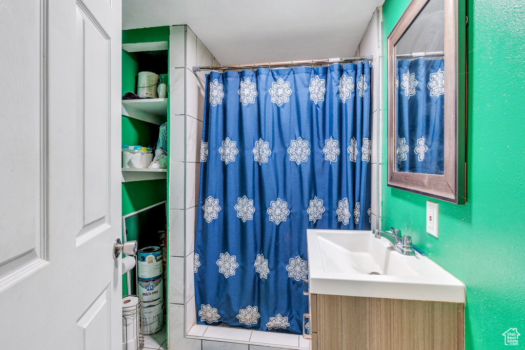 Full bath featuring curtained shower and vanity