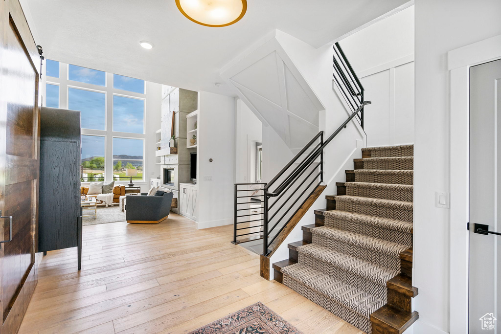 Stairs featuring recessed lighting, hardwood / wood-style flooring, and a fireplace