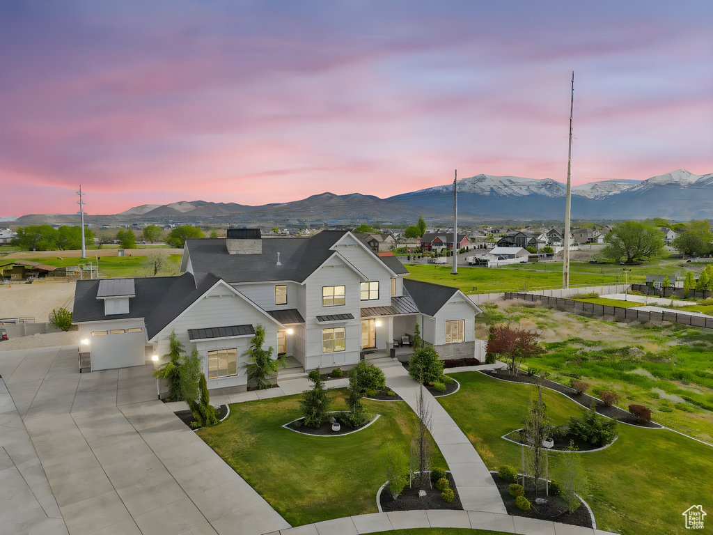 View of front facade featuring driveway, a standing seam roof, metal roof, and a mountain view