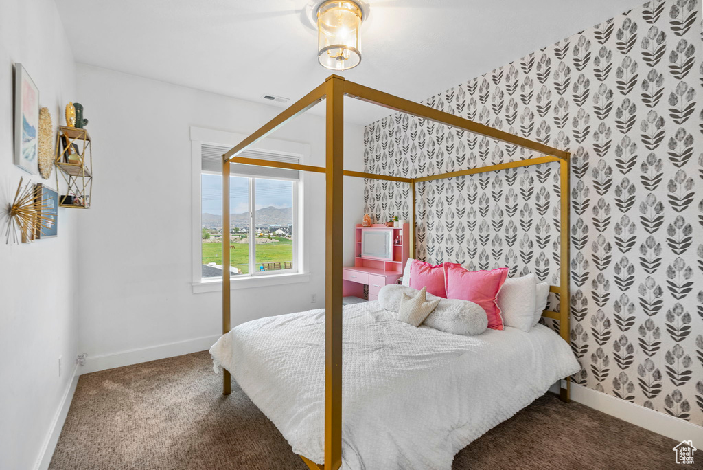 Carpeted bedroom with baseboards, wallpapered walls, and visible vents
