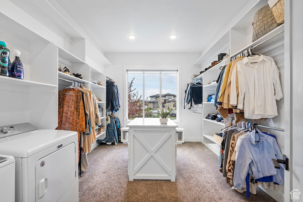 Spacious closet featuring independent washer and dryer and light carpet