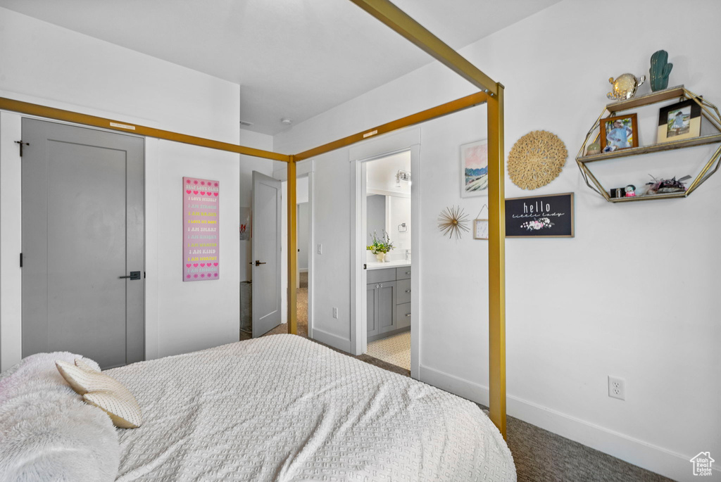 Bedroom with baseboards, ensuite bath, carpet floors, and a closet