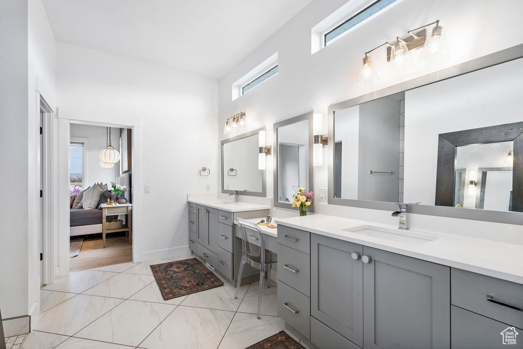 Full bathroom featuring a high ceiling, ensuite bath, marble finish floor, and a sink
