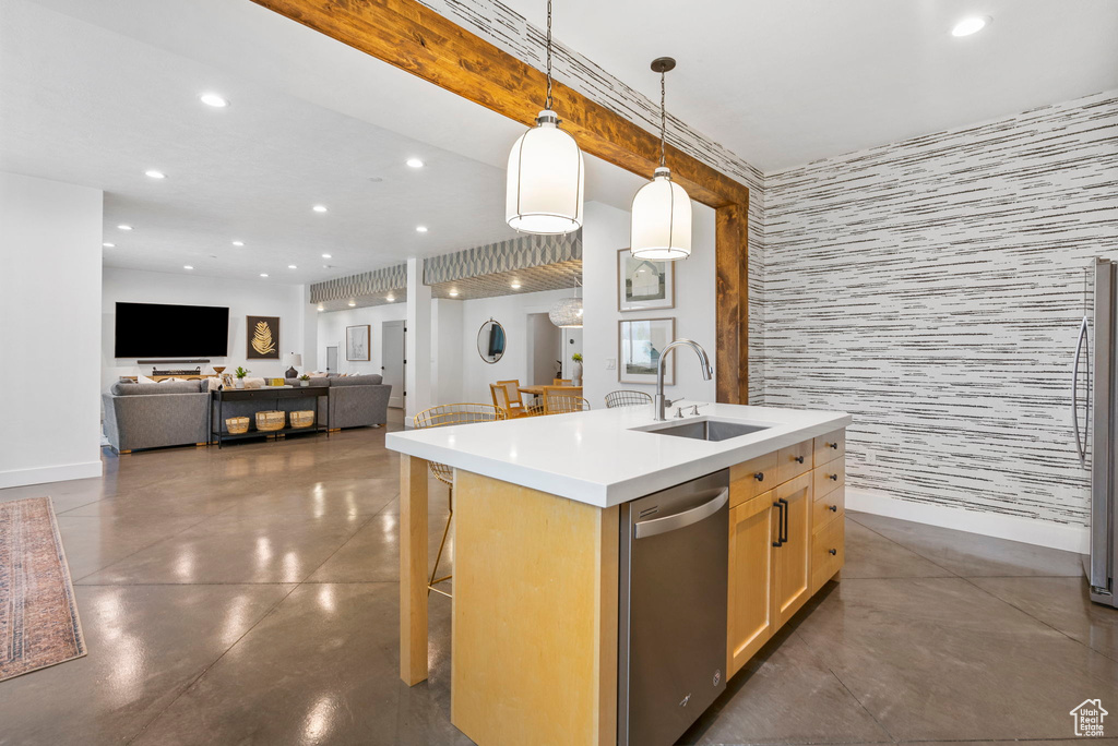Kitchen with recessed lighting, stainless steel dishwasher, a kitchen island with sink, finished concrete flooring, and a sink